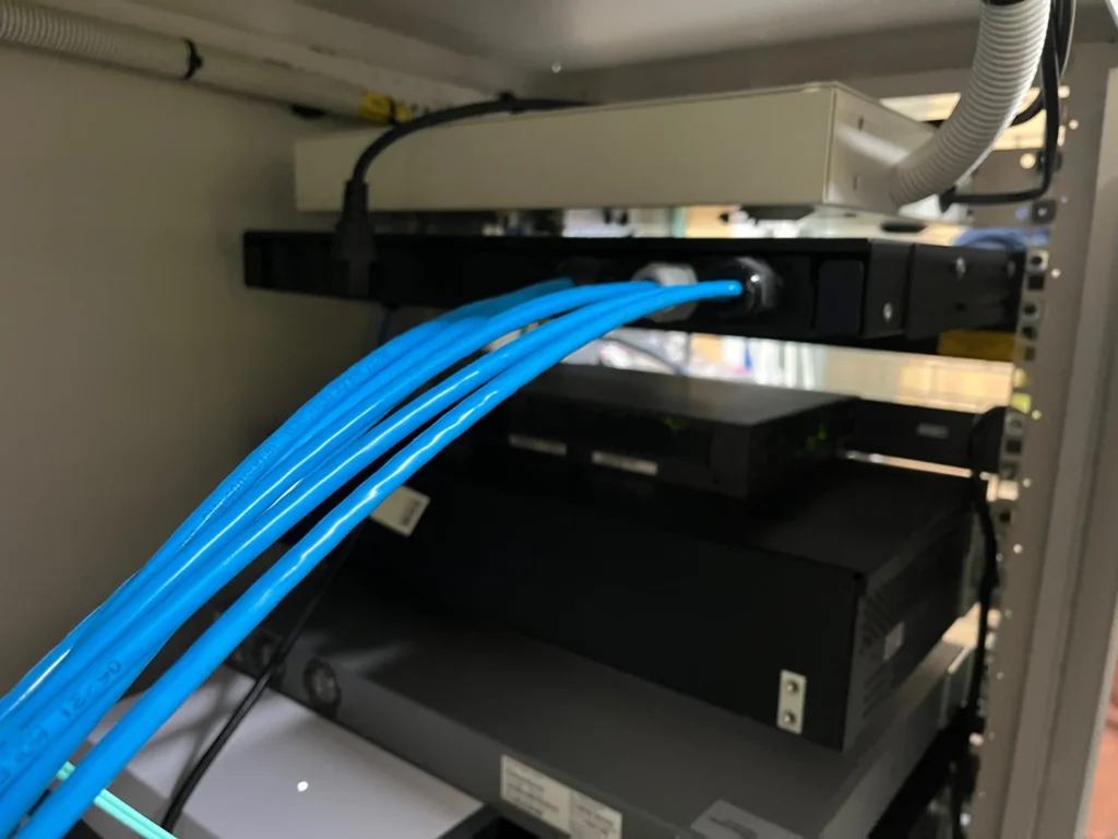 Blue data cabling in a cabinet at Carroll College