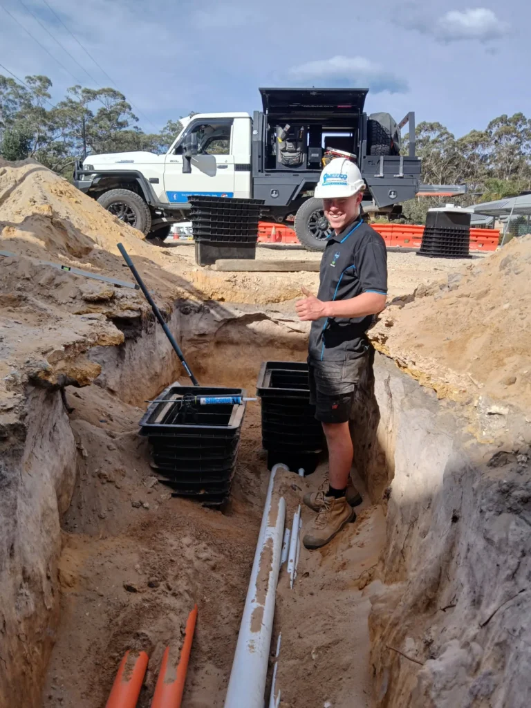 Electrician beside underground conduits and cable pits at Carroll College