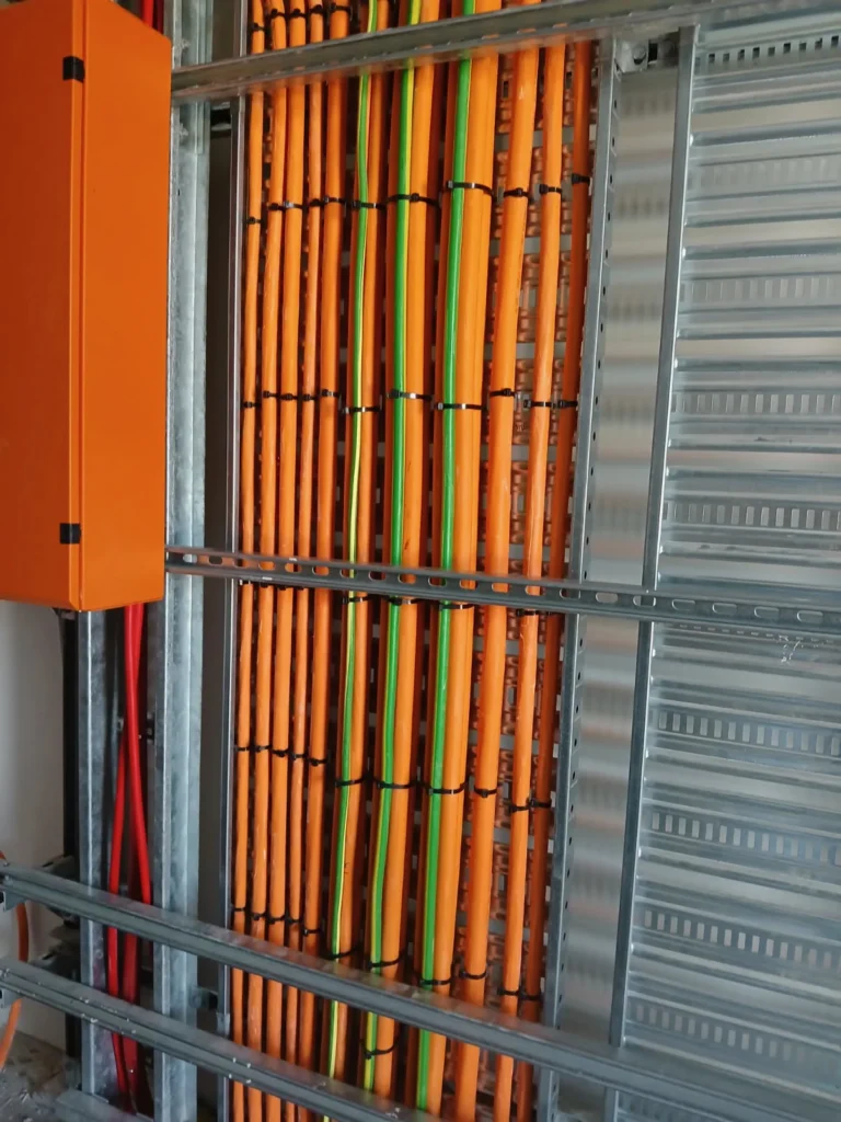 Orange submain cables secured to vertical cable supports at Eurobodalla District Hospital