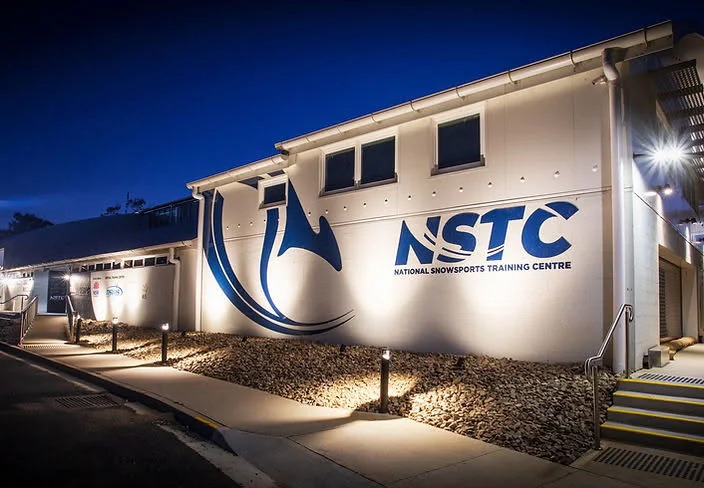 National Snowsports Training Centre exterior and signage illuminated at night