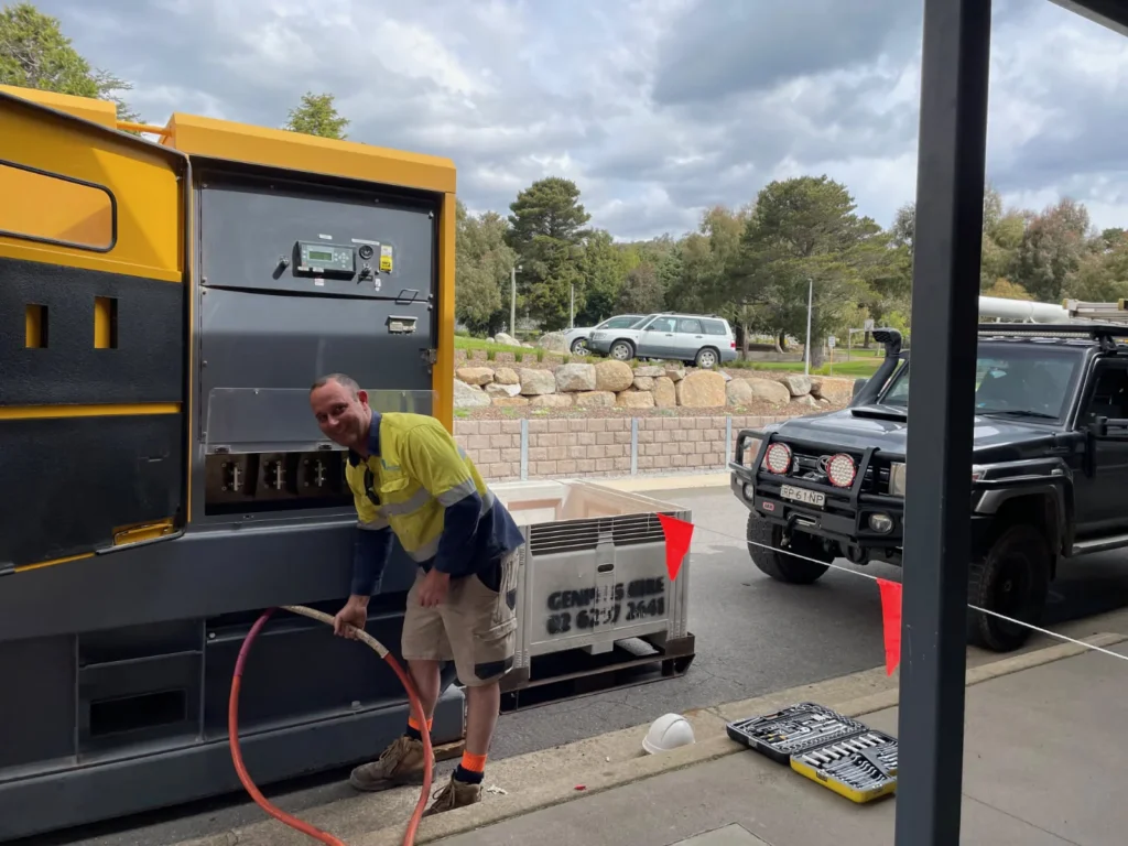 Electrician handling a cable beside yellow equipment at the Jindabyne training facility
